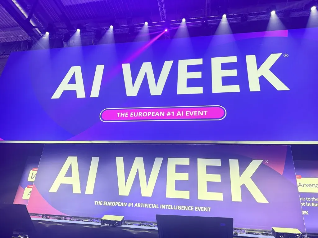 Schermi con il logo AI Week, l’evento europeo sull’intelligenza artificiale